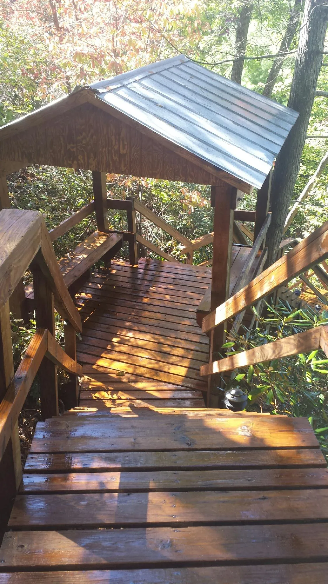 Freshly stained wood walkway and covered shelter with a metal roof in Creston